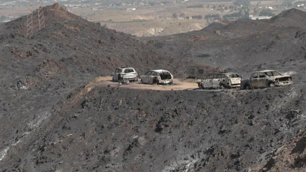Four cars surrounded by the ashes in the aftermath of a wildfire in Spain.