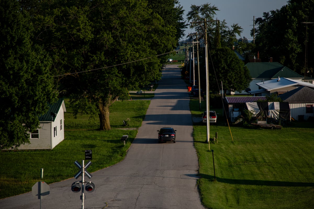 A car drives down a street in a small town.