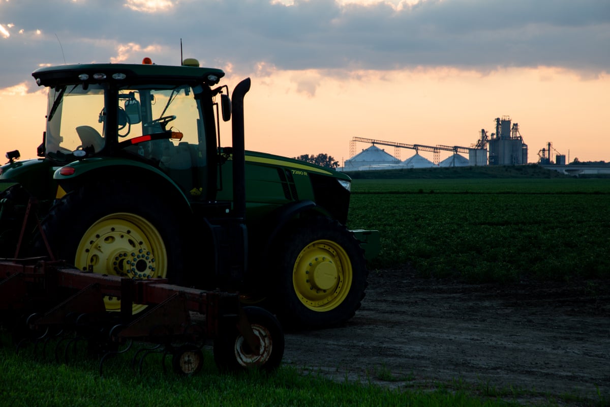 A tractor sits near a field.