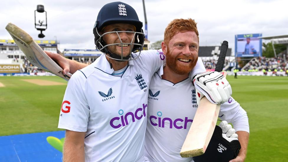 Joe Root and Jonny Bairstow both smiling with their arms around each other's shoulders as they walk off the pitch at Edgbaston in 2022