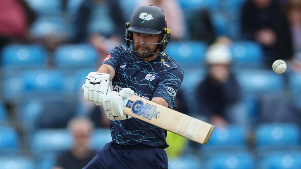 Adam Lyth in blue playing Yorkshire kit and a batting helmet cuts the ball during a T20 Blast match