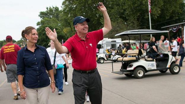 Nordone (left) seen at the Iowa state fair in 2015 with her older brother. She wears a blue shirt and he wears a red shirt and blue hat. There is a golf cart near them