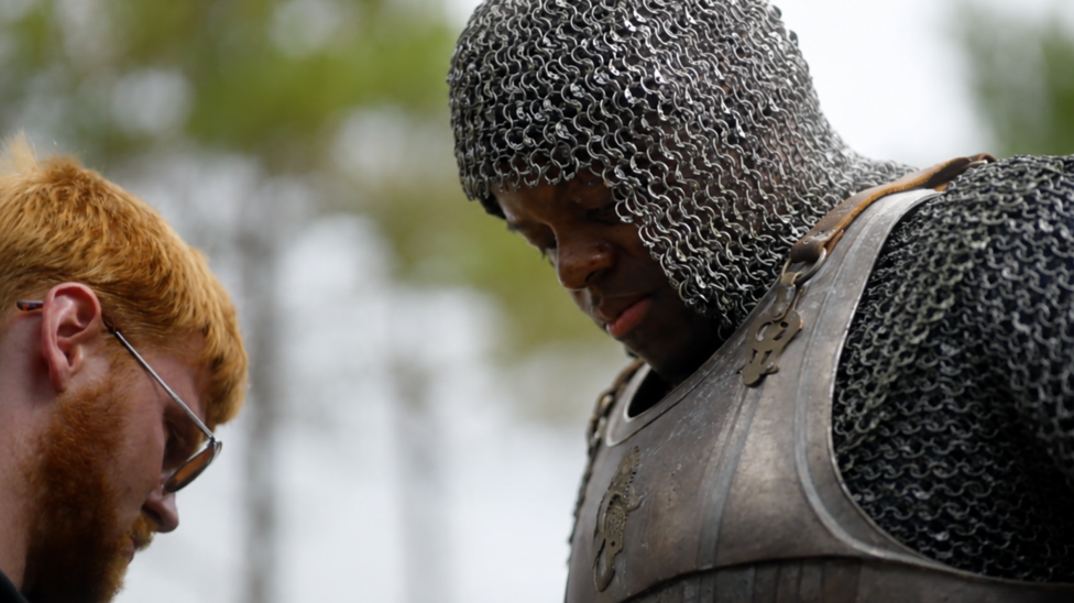 Aaron with man dressed as knight in armour facing each other