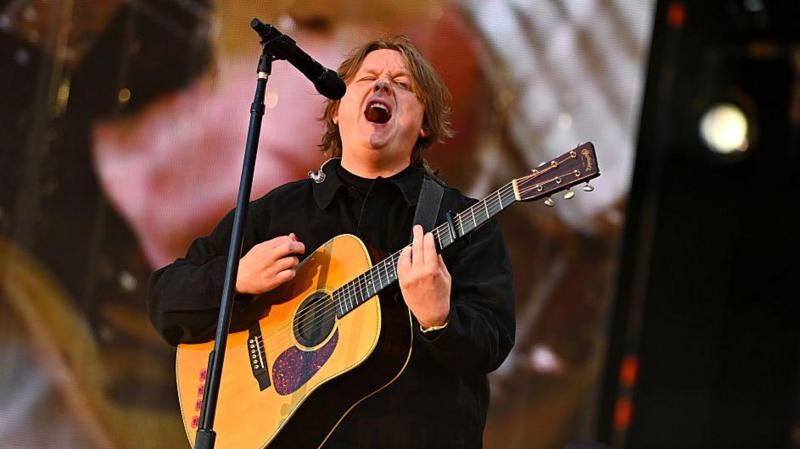 Lewis Capaldi playing guitar and singing on stage