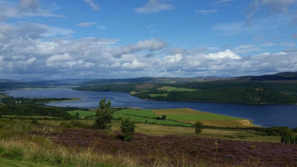 Struie in the Scottish Highlands. A picture of the green landscape with a blue sky and river. 