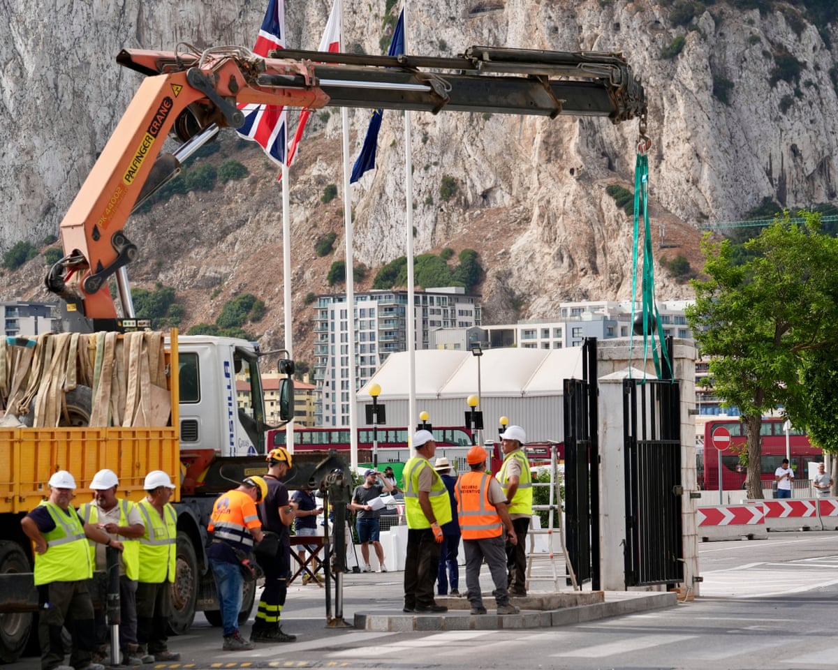 Workers with a crane remove the iron gates of the border at La Línea de la Concepción on Wednesday.