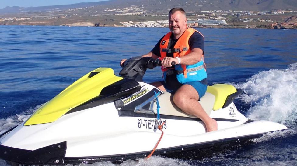 Griffiths driving a jet ski in an exotic location