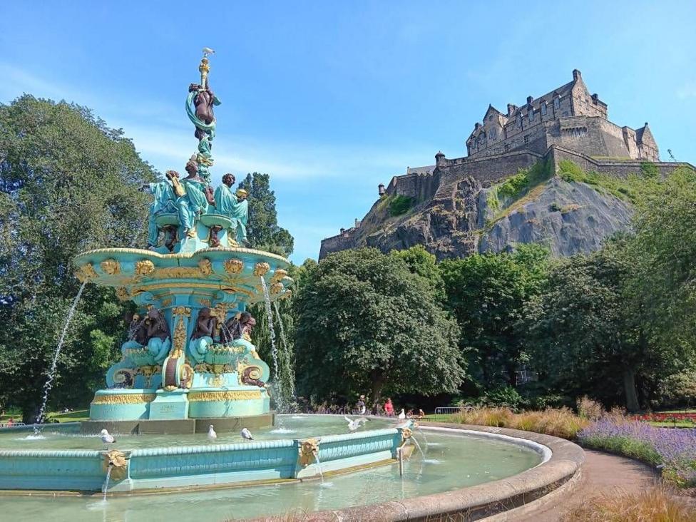 Ornate fountain in Princes Street Gardens with Edinburgh Castle above.