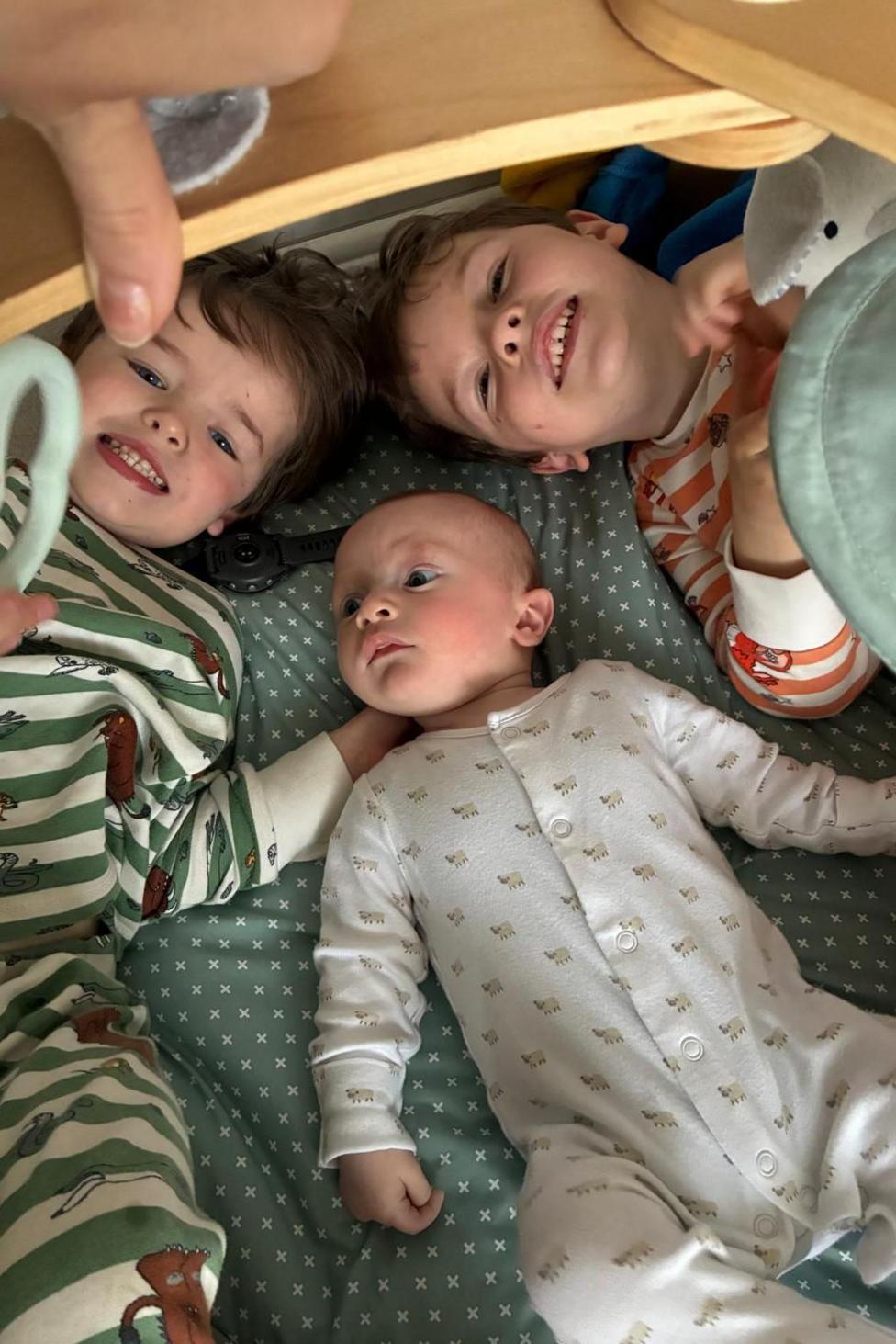 Big brothers huddle around a baby