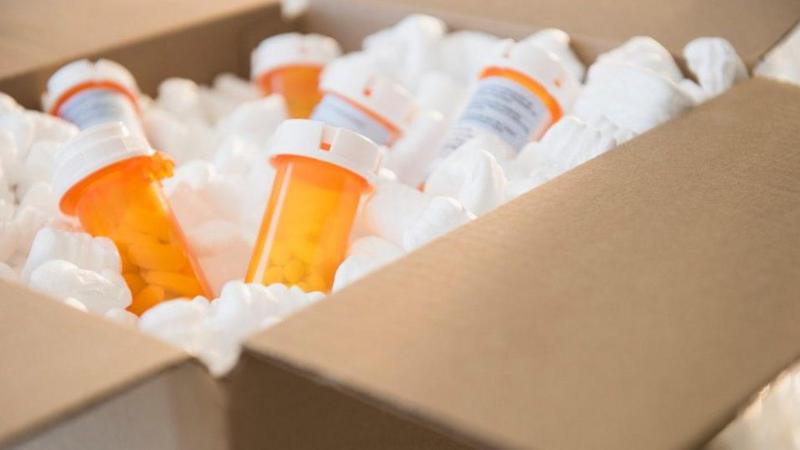 Collection of tablets in orange bottles with white tops, contained within a brown cardboard box.