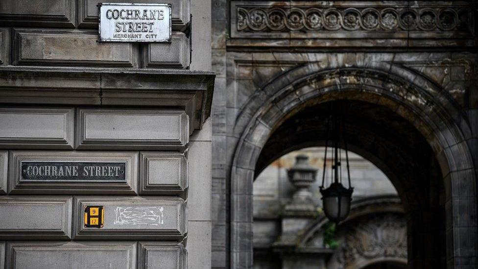 An archway on Cochrane Street, with two signs - both displaying the street's name - visible.