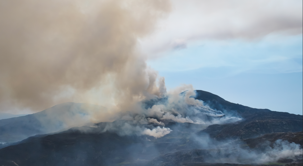 Smoke from a mountain fire climbs high into the atmosphere