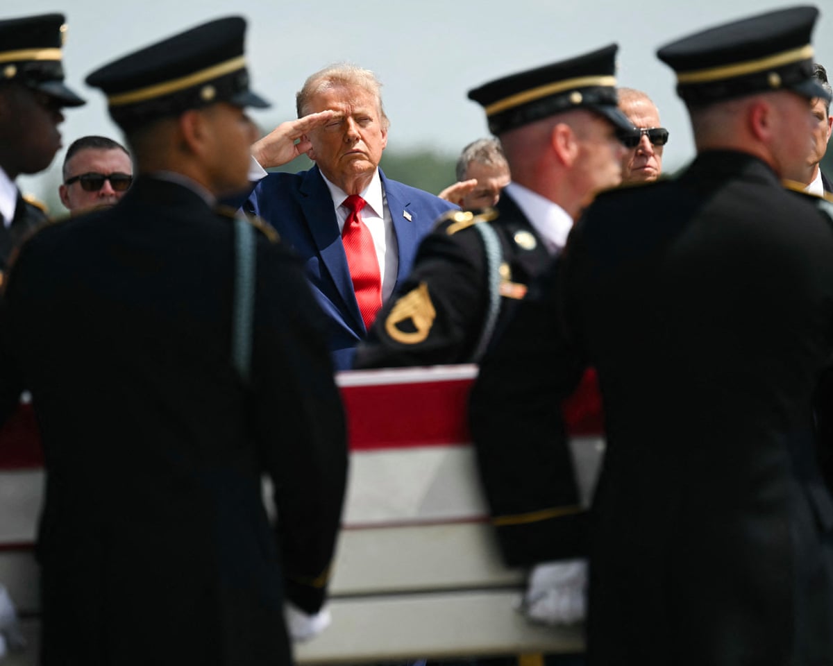 Donald Trump salutes as a US Army carry team carries the flag-draped transfer case at Dover Air Force Base in Dover, Delaware.