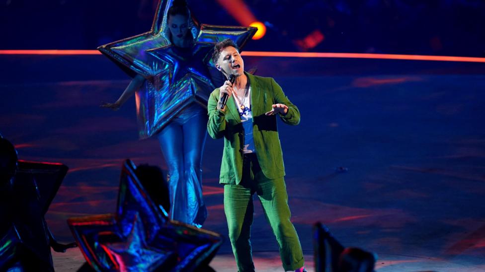 Callum Beattie in a green suit singing on stage