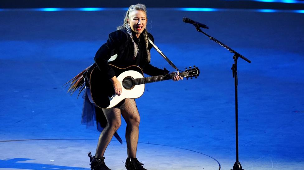 KT Tunstall in black outfit and playing a guitar as she sings on stage