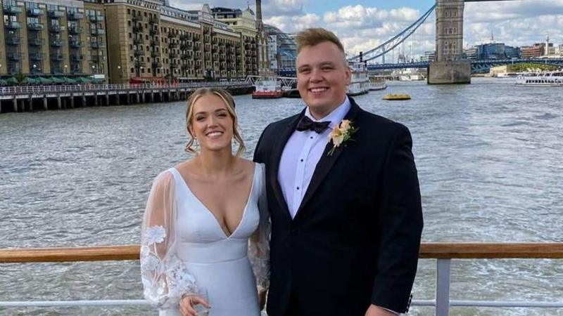 Hannah and Max smiling on their wedding day in front of Tower Bridge