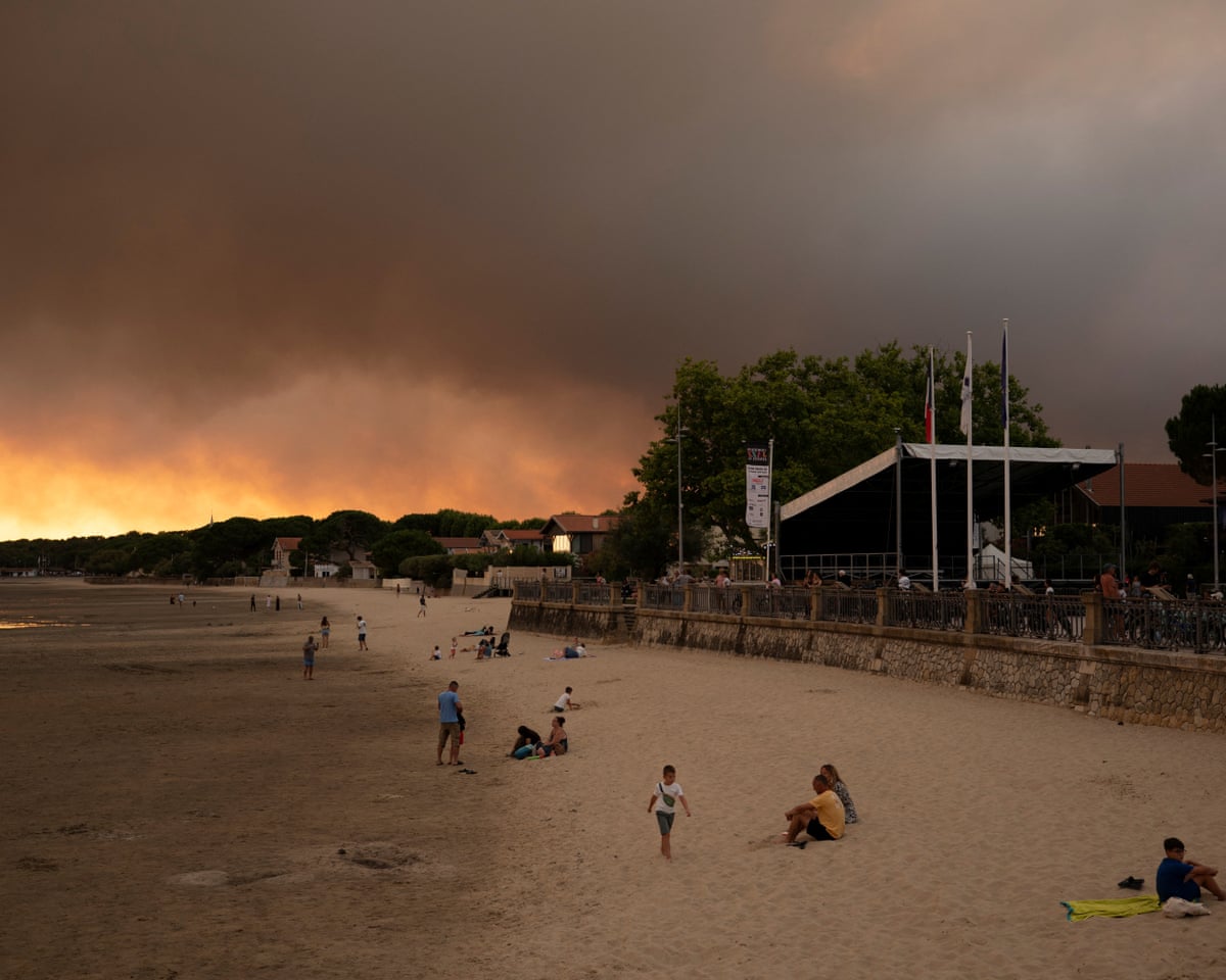People on the beach in Andernos-Les Bains during fire in Lege Cap-Ferret forest, southwestern France.