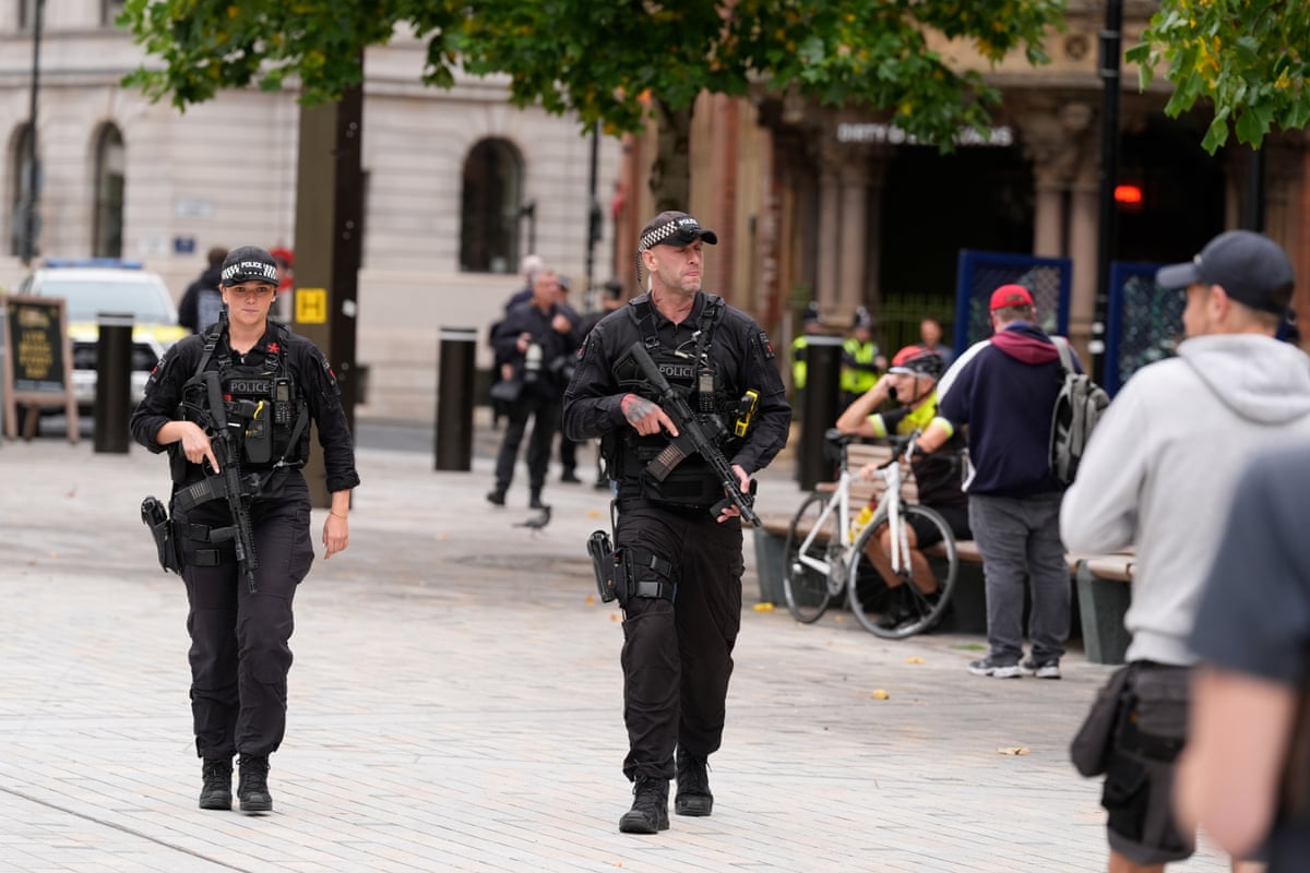 Two armed police officers patrol the streets in central manchester.