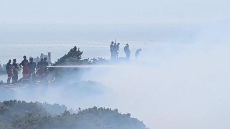 Fire crews shooting jets at a smokey area