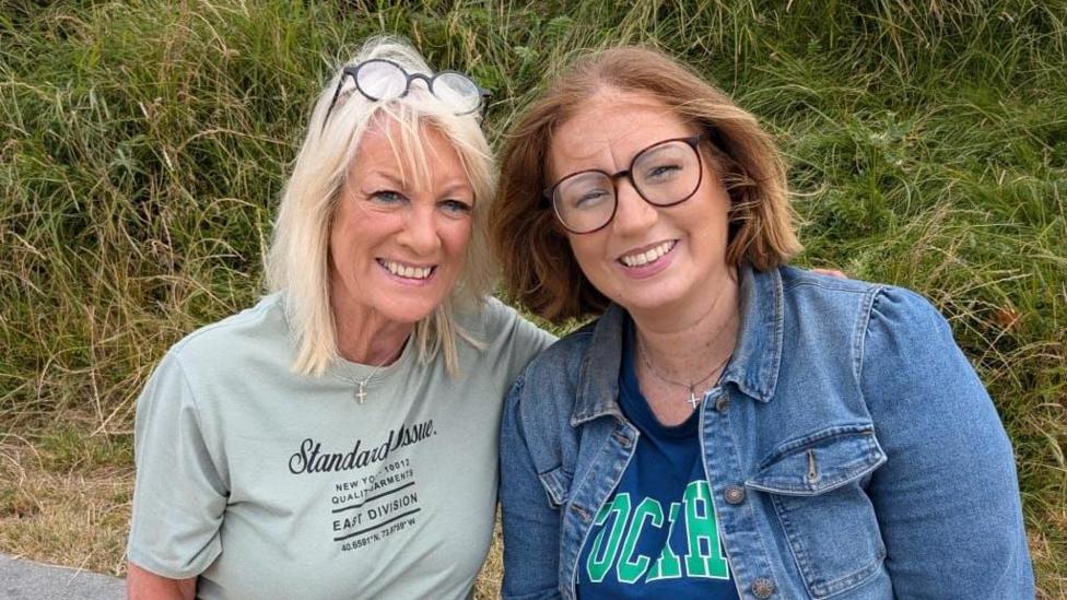 Sally Gower (left) and Hayley Spence (right). Sally is wearing a green shirt and has long blonde hair. Hayley is wearing a denim jacket and blue top. She is also wearing glasses and has brunette hair. 