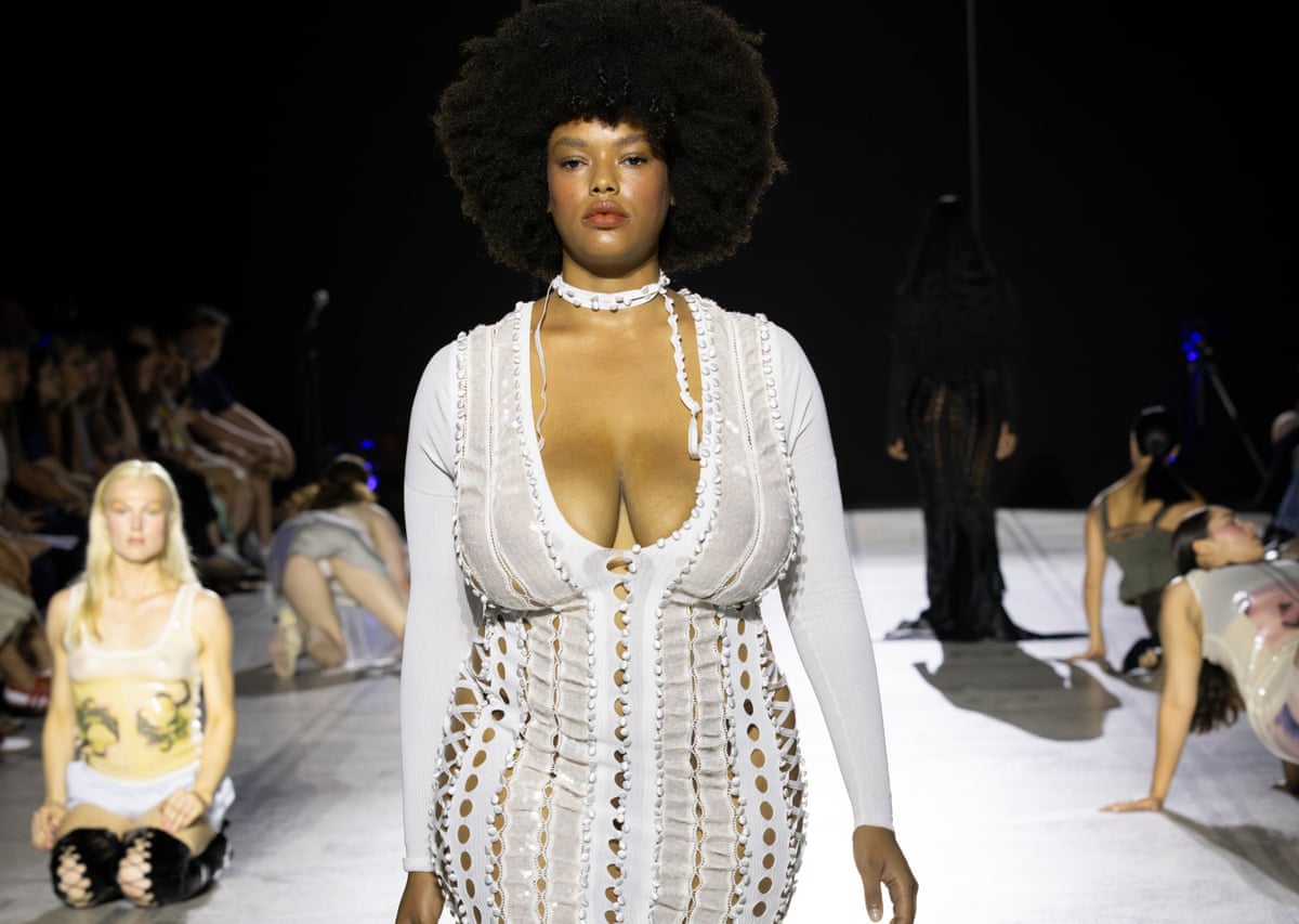 Model wearing white laced dress on a catwalk