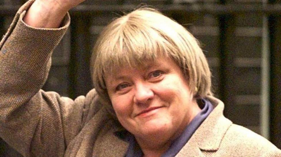 Northern Ireland Secretary, Mo Mowlam, arrives at No 10 Downing Street. She has short blond hair. She's waving and wearing a tweed jacket or coat.