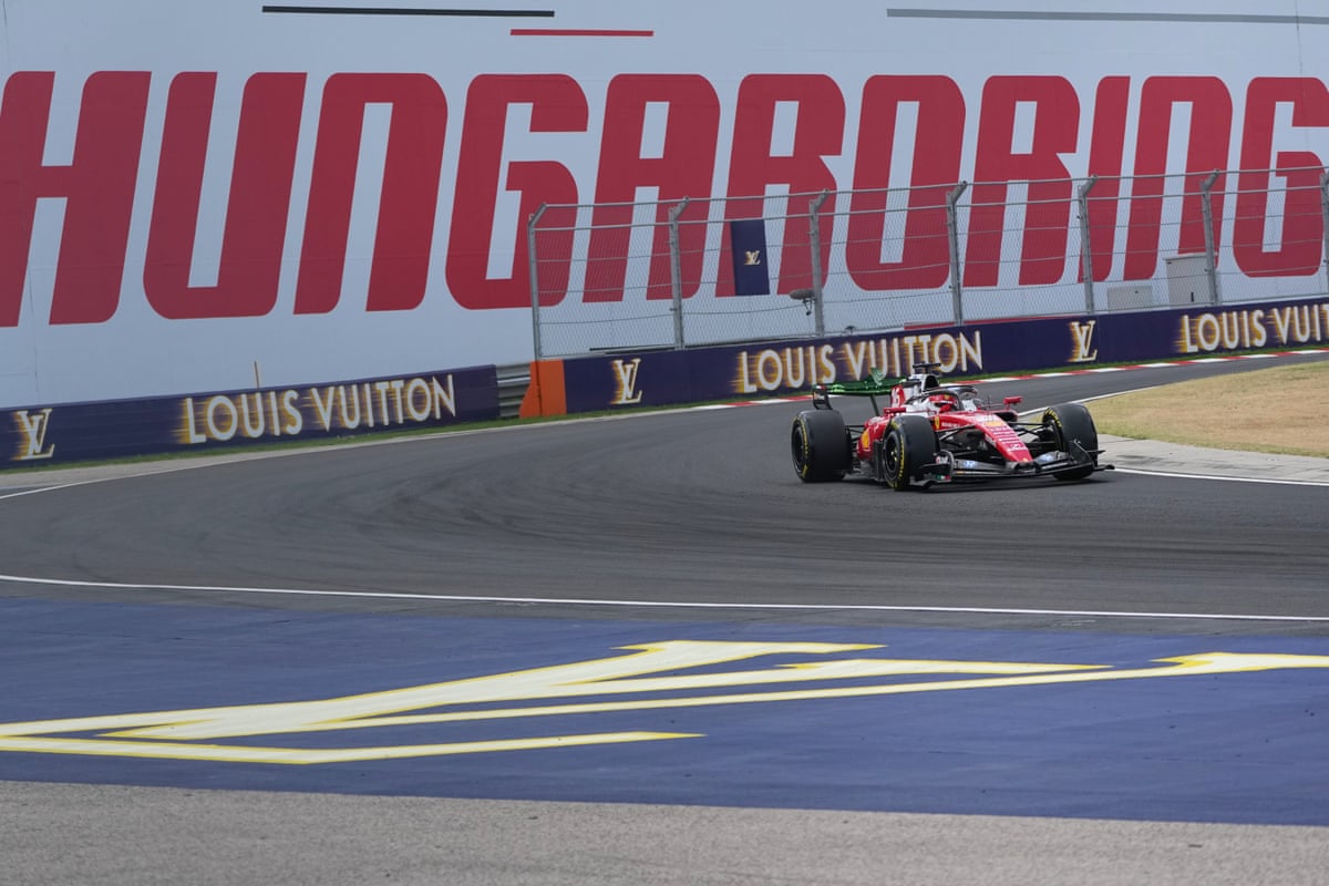Charles Leclerc during first practice drives past a sign saying Hungaroring