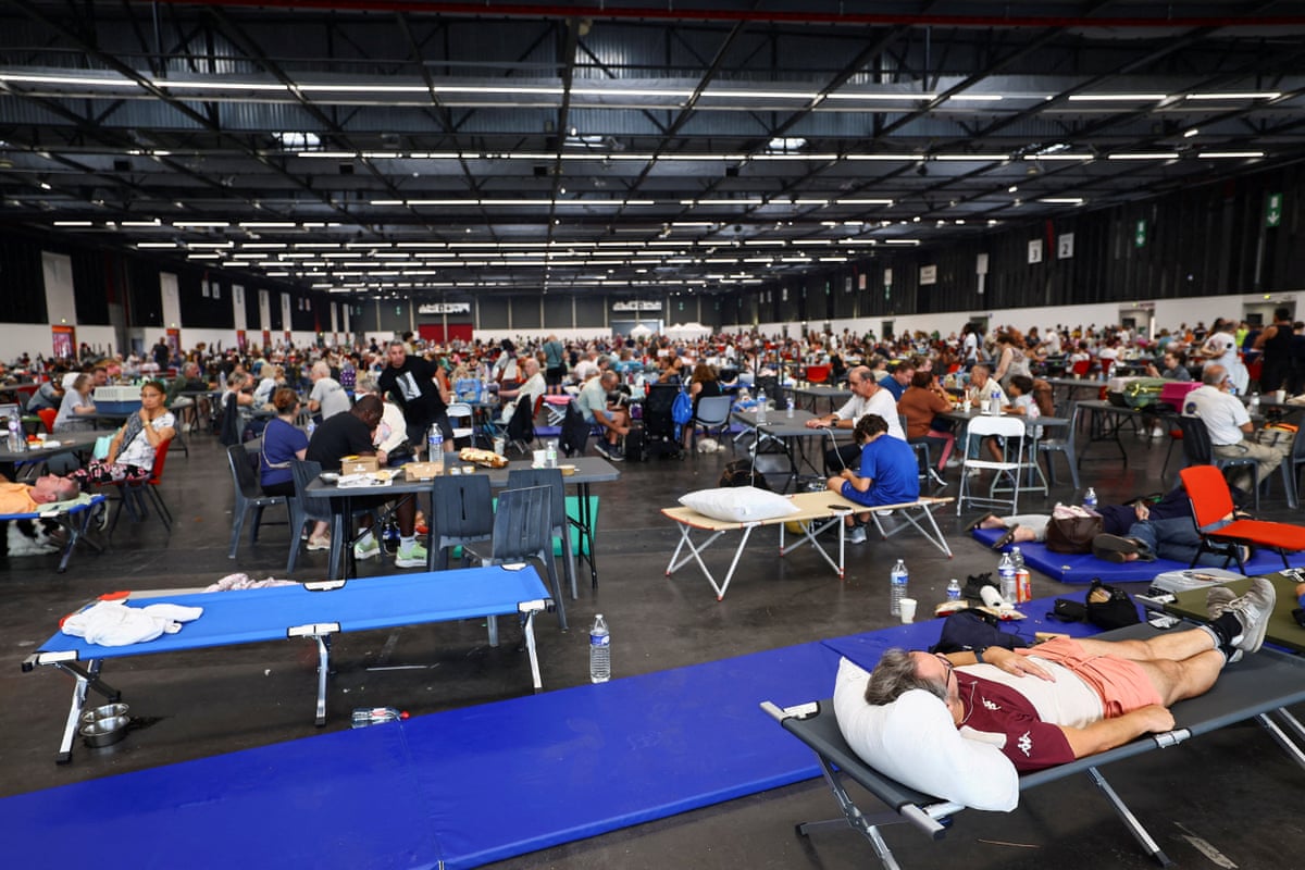 A large exhibition centre with people lying in beds