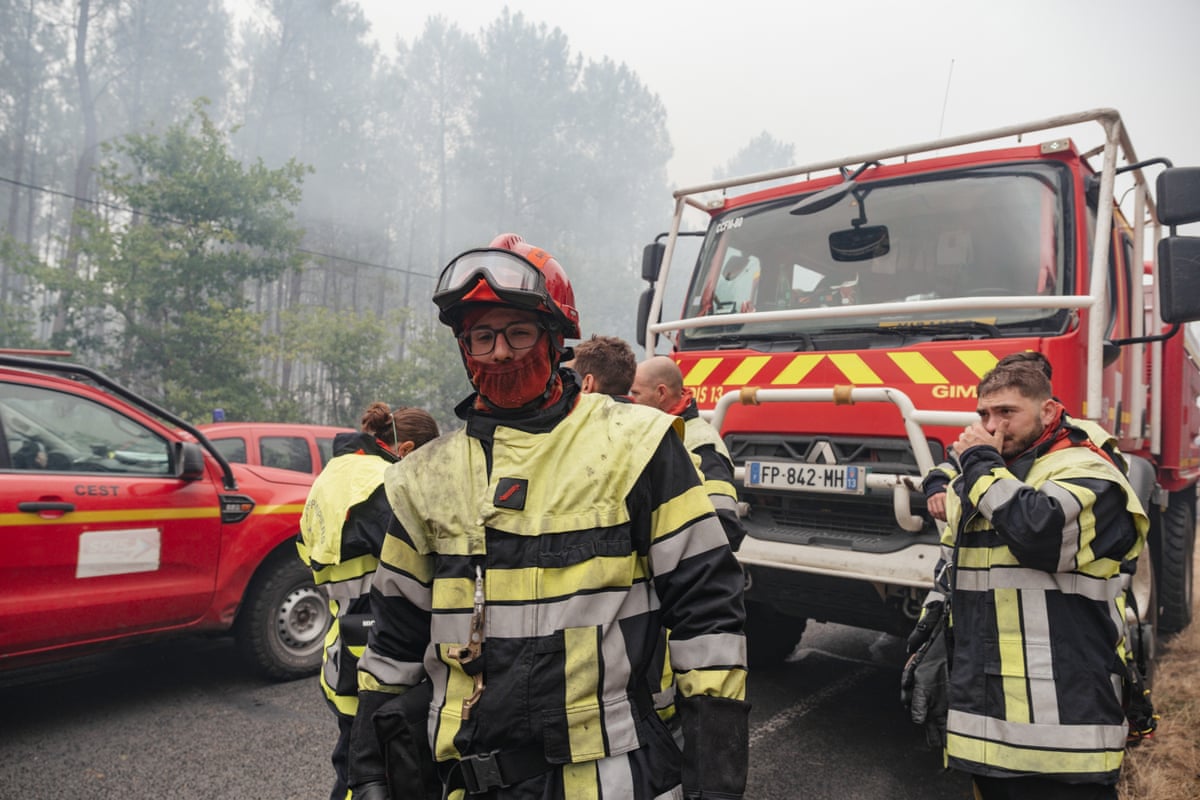 Firefighters in protective gear next to a fire truck
