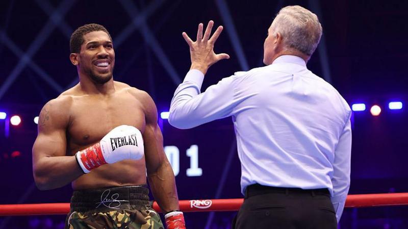 Anthony Joshua smiles when being given the referee's count for the second time in round one