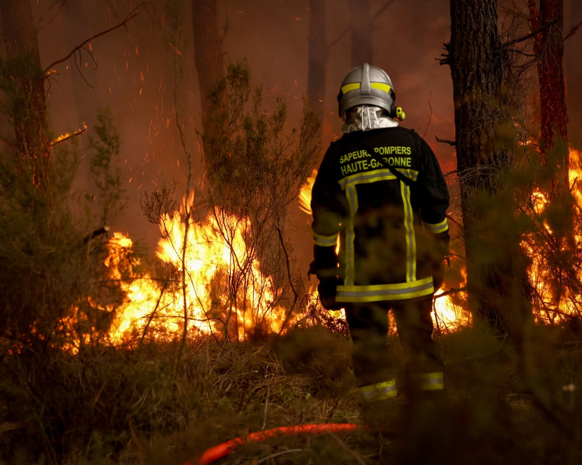 A firefighter stands before flames as a forest fire rages in Saint-Jean-d'Illac, some 30km from Bordeaux, France.