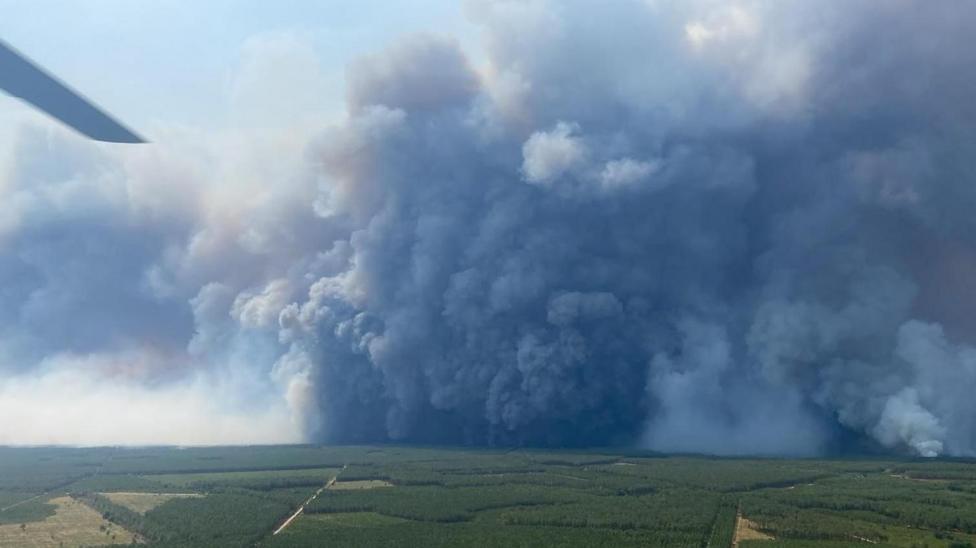 A handout photo made available by the Departmental Fire and Rescue Service 22 (SDIS33) shows a pyrocumulonimbus, a giant cloud created by a large fire as seen from a fire fighter helicopter over the village of Saumos, France, 25 July 2026.