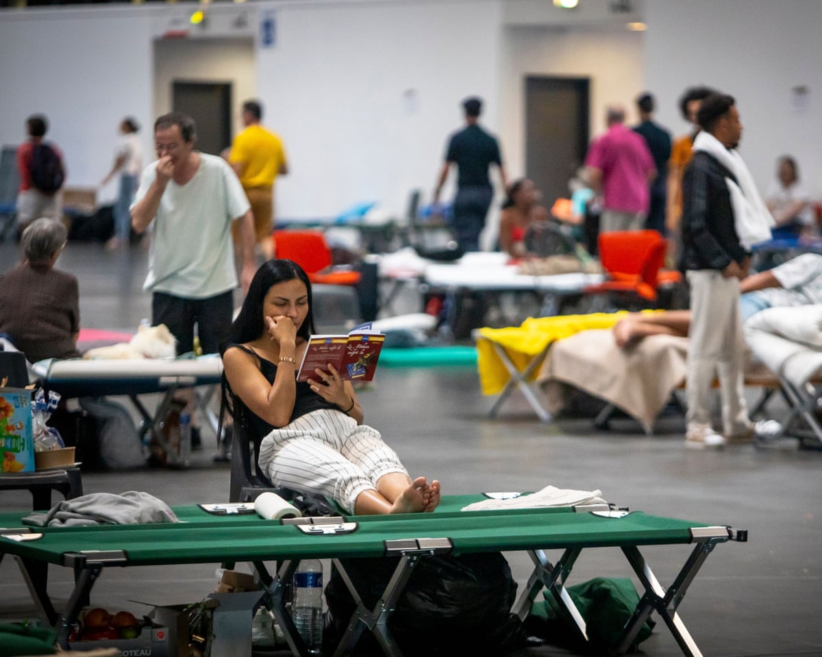 Thousands of people evacuated from their homes rest at the Bordeaux Exhibition Centre, which has been converted into a temporary emergency shelter following a major wildfire affecting the Gironde department in southwestern France.
