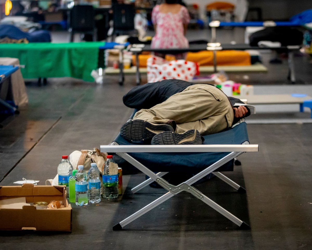 Thousands of people evacuated from their homes rest at the Bordeaux Exhibition Centre, which has been converted into a temporary emergency shelter following a major wildfire affecting the Gironde department in southwestern France.