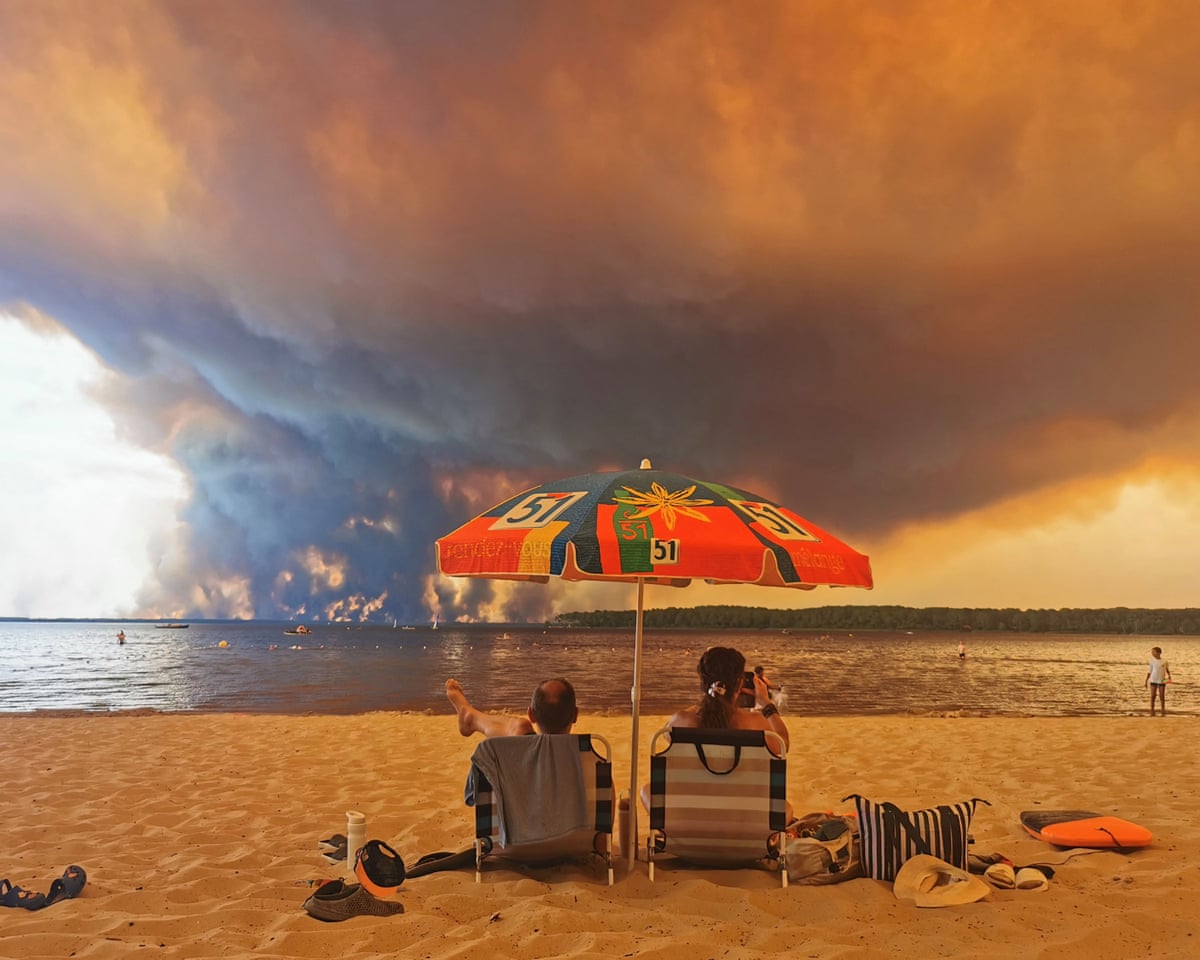Beach goers sit on the beach of Moutchic in Lacanau, southwestern France.