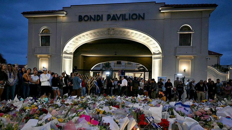 A large arched building in the background says 