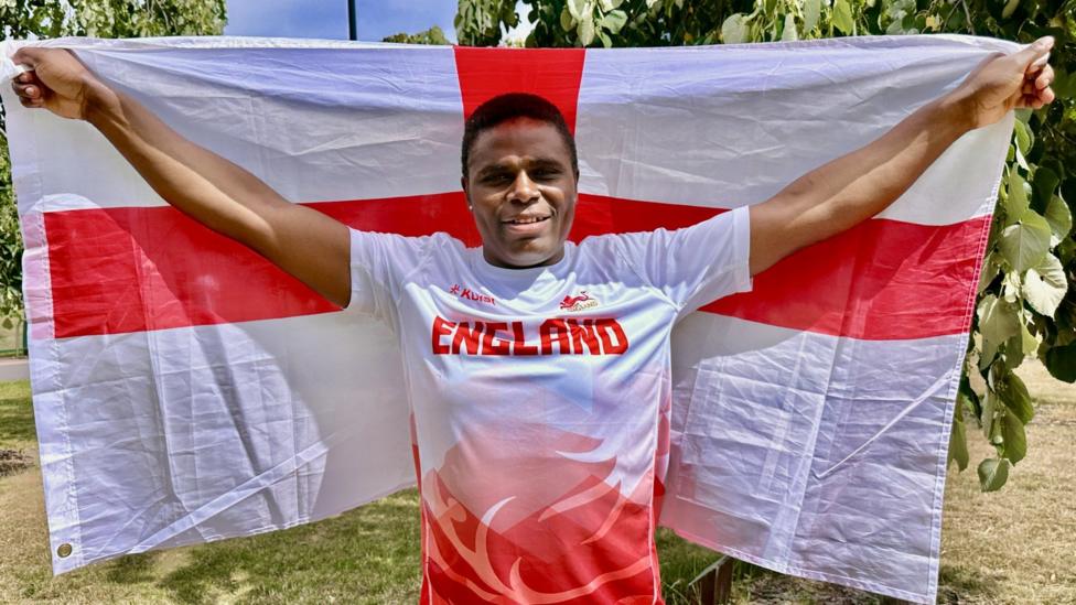 Madias Ngake holding an England flag