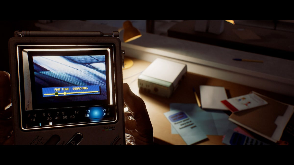 Hands in darkened room examine a screen device … Silent Hill: Townfall.