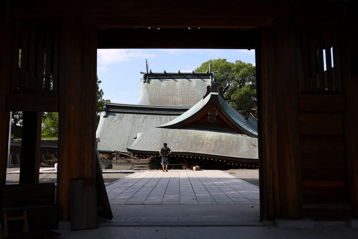 A man stands outside a collapsed temple. 