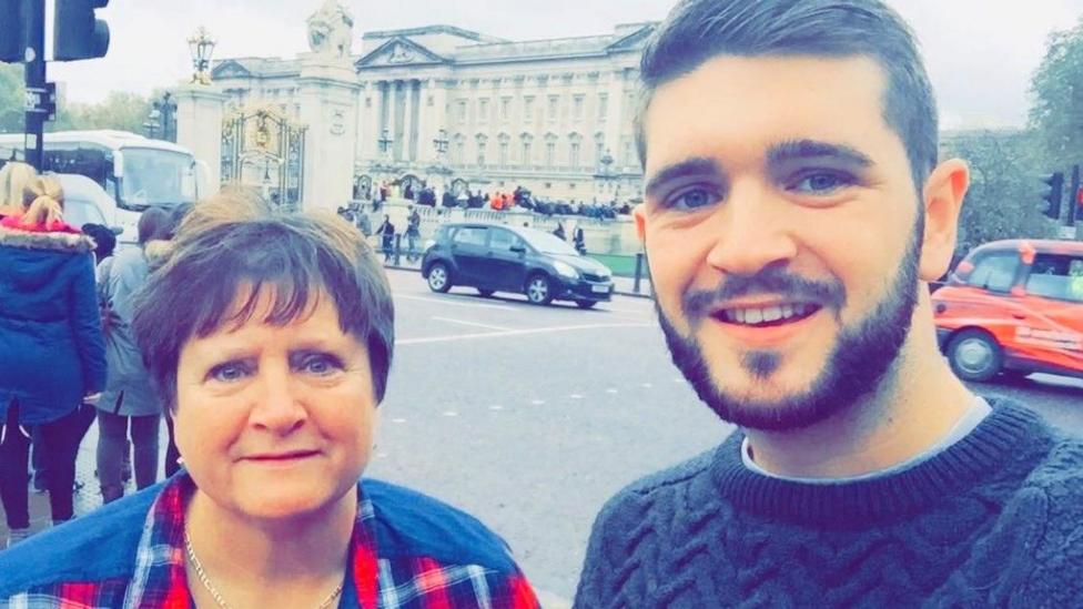 Larraine Hutcheon pictured with her son Kieran in a smiling selfie, with Buckingham Palace in the background.