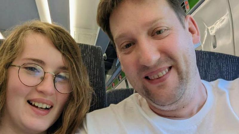 Sophie Daniels and her father Stephen are pictured smiling and looking directly at the camera. Sophie wears glasses. Her father wears a white T-shirt.