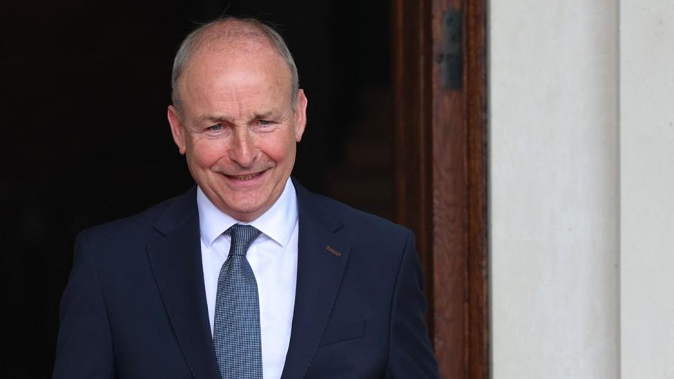 Taoiseach Micheál Martin. Grey hair, blue suit.
