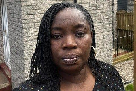 Jumoke Adebajo, a woman looking at the camera standing outside her home.