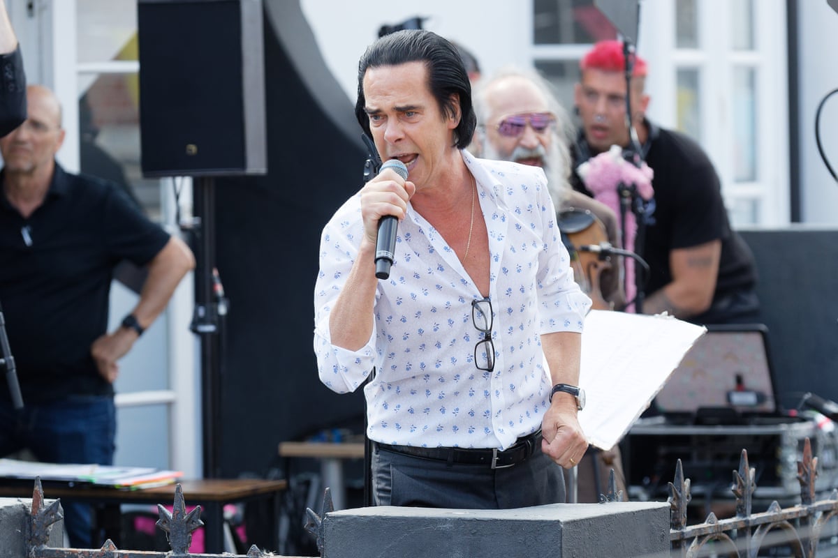 Nick Cave in a white shirt singing from the balcony of Resident Records