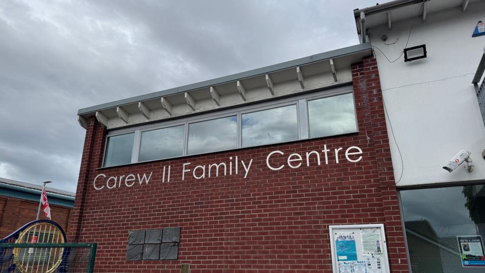 The exterior of the Carew Family Centre in east Belfast. It has 'Carew Family Centre' written in large, silver letters on the side of the red brick, two-storey building.