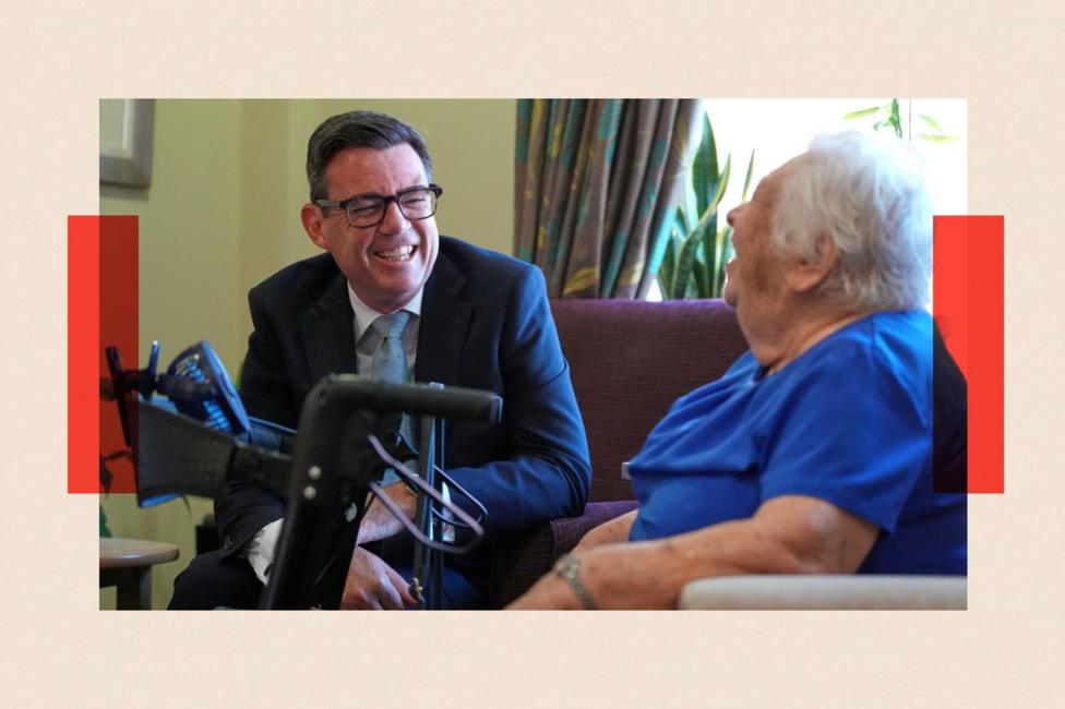 Britain's Prime Minister Andy Burnham talks to a resident during a visit to a care home in London