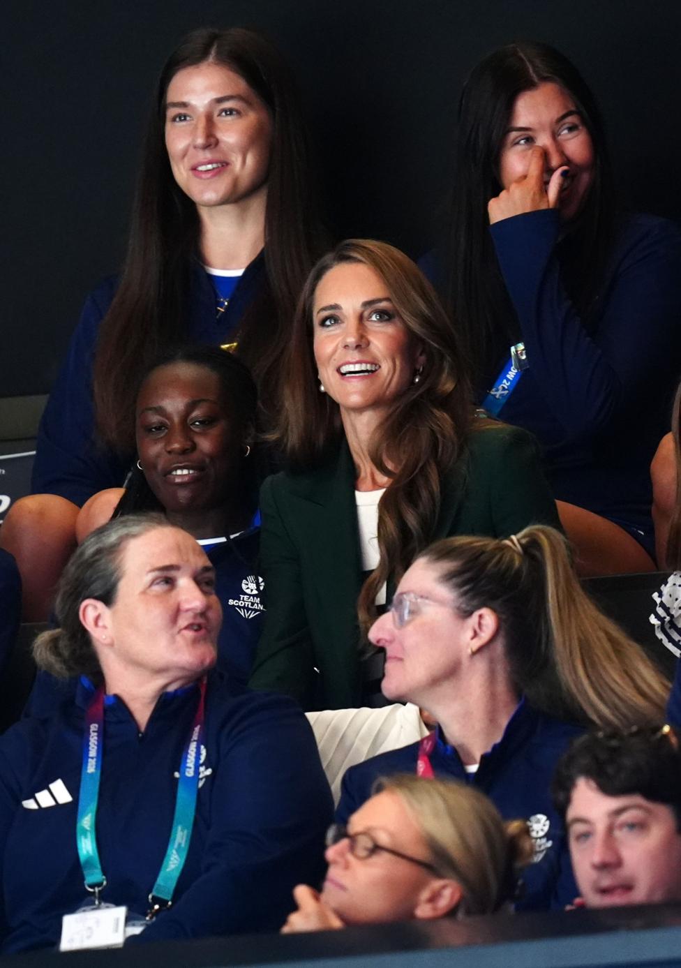 The Duchess of Rothesay in a crowd watching a netball match - she is smiling and is gazing upwards