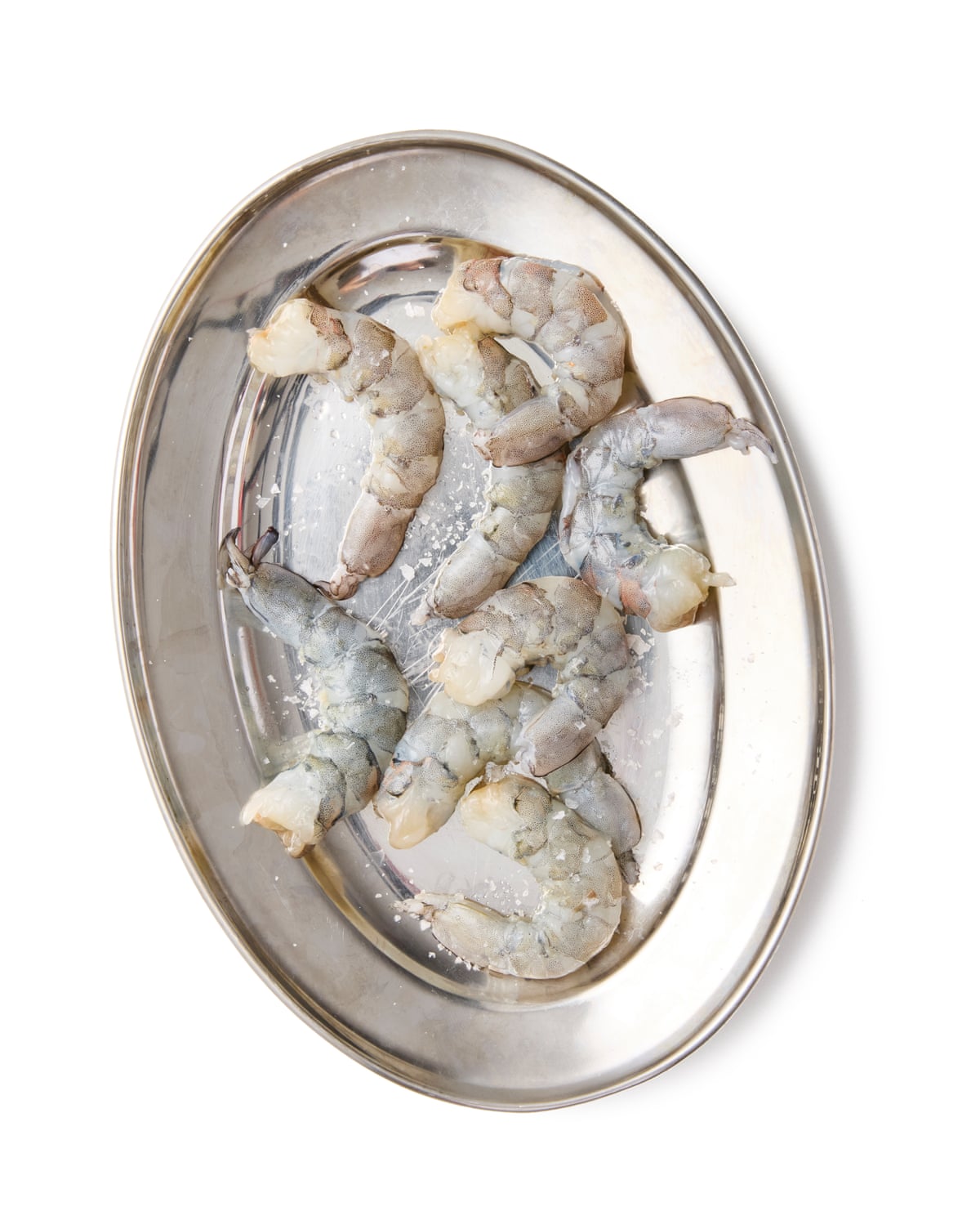 A plate of peeled, raw prawns, salted