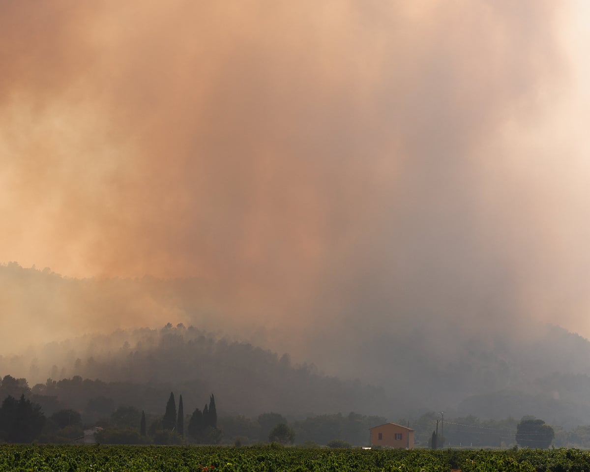 Smoke above countryside and a few houses