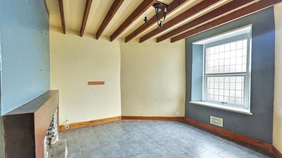 An empty lounge with a large window and a fireplace